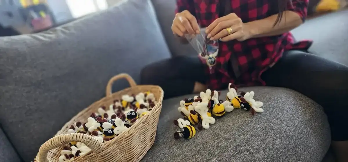 Multiple handmade bees spread on grey sofa with basket - home production